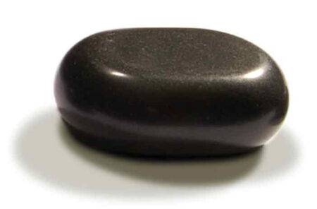 Large massage stones in use on arm